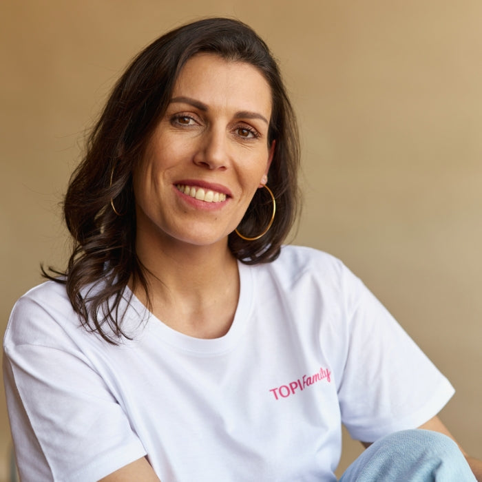 MUJER SONRIENTE SENTADA EN UNA SILLA