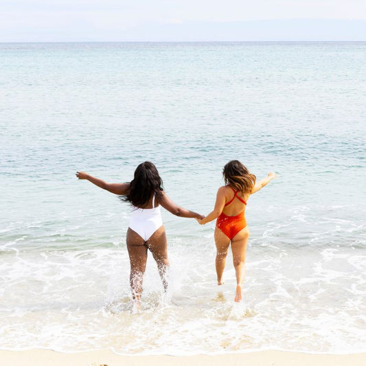 2 MUJERES CORRIENDO HACIA EL MAR