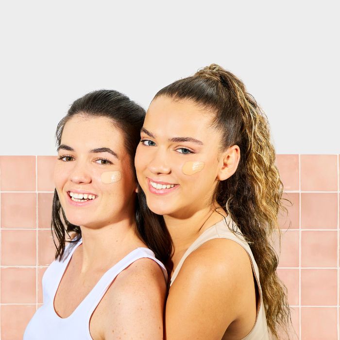 DOS MUJERES CON CREMA TEÑIDA EN LAS MEJILLAS