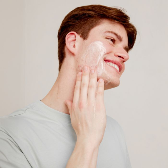 HOMME-AVEC-ACNE-QUI-S'APPLIQUE-UN-GEL-NETTOYANT