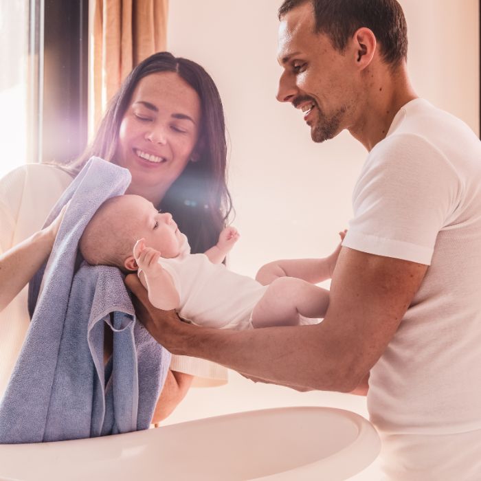 UN-HOMME-ET-UNE-FEMME-QUI-TIENNENT-LEUR-BEBE-ET-SECHENT-SON-CUIR-CHEVELU
