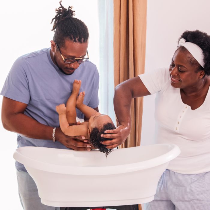 UN-PERE-ET-UNE-MERE-DONNENT-LE-BAIN-A-LEUR-BEBE