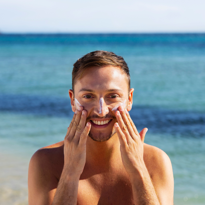 HOMME-QUI6APPLIQUE-UNE6cREME-SOLAIRE-SUR-LE-VISAGE