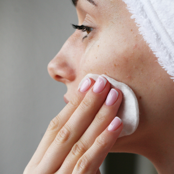 FEMME-QUI-NETTOIE-AVEC-UN-COTON-UNE-PEAU-ACNEIQUE