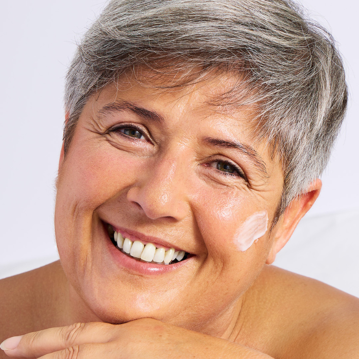 Femme-souriante-crème-sur-visage